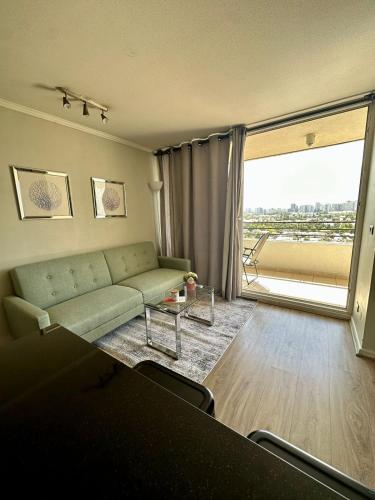 a living room with a couch and a large window at Departamento Vista Hermosa in Santiago
