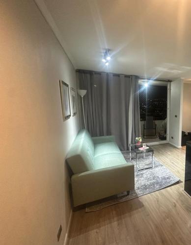 a living room with a green couch and a table at Departamento Vista Hermosa in Santiago