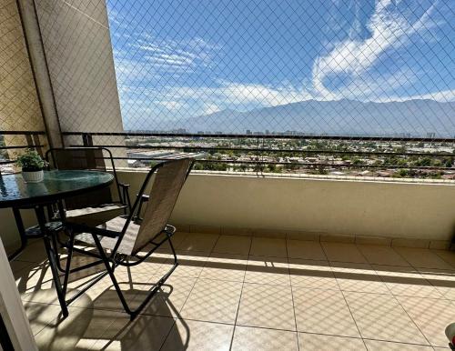 a balcony with a table and chairs and a large window at Departamento Vista Hermosa in Santiago