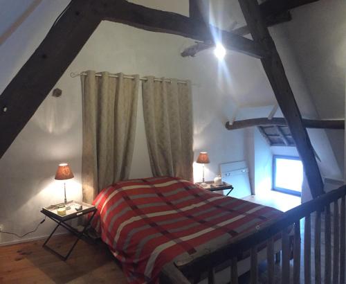 a bedroom with a bed and two lamps on tables at Linotte Chaumière des Marionnettes in La Chapelle-des-Marais