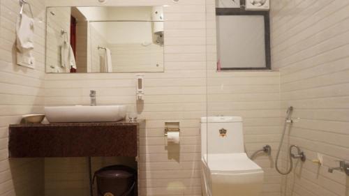 a bathroom with a sink and a toilet and a mirror at Wow Relish in Alwar