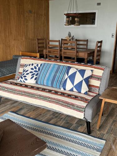 a couch with pillows on it in a living room at Cabańas de La Ochi in Niebla