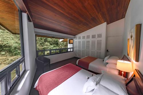 a small bedroom with two beds and a window at Hotel Bambito By Faranda Boutique, a member of Radisson Individuals in Cerro Punta