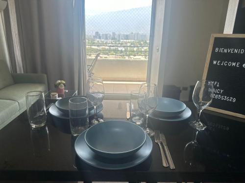 a table with plates and wine glasses on it at Departamento Vista Hermosa in Santiago