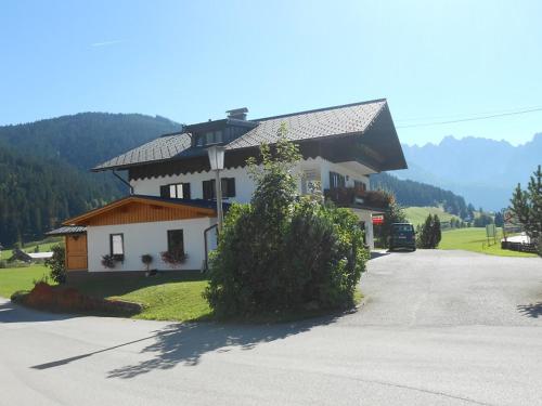 a large white house in the middle of a road at Ammoniten Blick - Appartement Gustav Gapp in Gosau