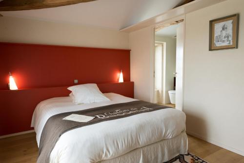 a bedroom with a large bed with a red wall at Hôtel-Restaurant le Château de Besseuil, Mâcon Nord - Teritoria in Clessé