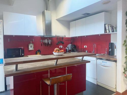 - une cuisine rouge avec un bol de fruits sur un comptoir dans l'établissement Agréable Duplex T3 - Coeur de Ville, à Six-Fours-les-Plages