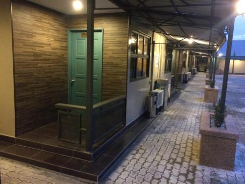 a hallway of a building with a green door at Talents Motor Park Hotel in Klang