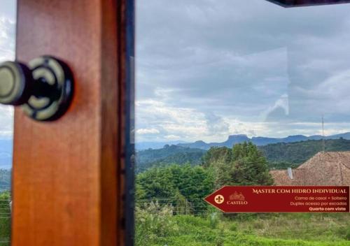 a close up of a door with a sign on a window at Hotel Castelo Nacional Inn Campos do Jordão in Campos do Jordão