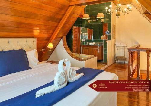a stuffed swan on a bed in a room at Hotel Castelo Nacional Inn Campos do Jordão in Campos do Jordão