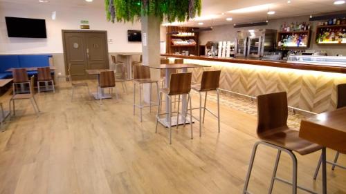 a bar in a restaurant with chairs and tables at Hotel Los Desmontes in Membrilla