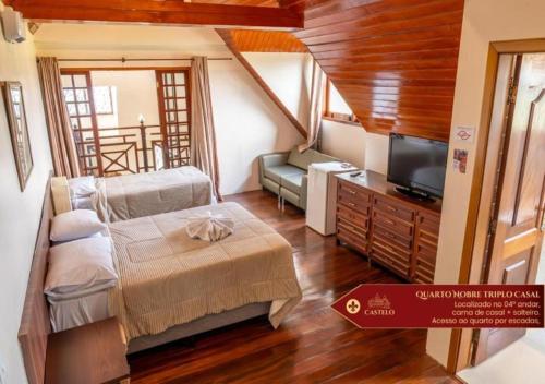 a room with a bed and a tv and a couch at Hotel Castelo Nacional Inn Campos do Jordão in Campos do Jordão
