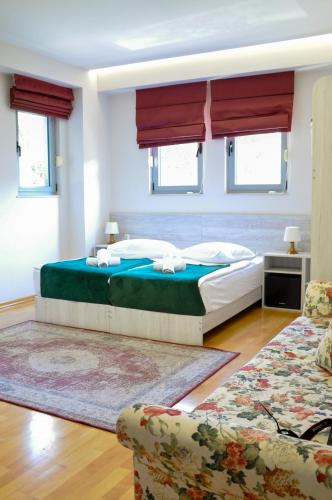 a bedroom with a large bed and two chairs at Boutique Hostel Livia in Metković