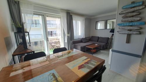 un salon avec une table et un canapé dans l'établissement COUCHANT RADIEUX Appartement 2 pièces 4 personnes vue mer, à Saint-Jean-de-Monts