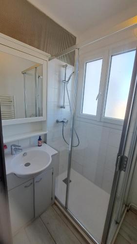 une salle de bain blanche avec une douche et un lavabo dans l'établissement COUCHANT RADIEUX Appartement 2 pièces 4 personnes vue mer, à Saint-Jean-de-Monts