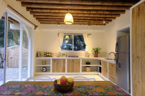 a kitchen with a table with a bowl of fruit on it at Tierra Munay in Las Tunas