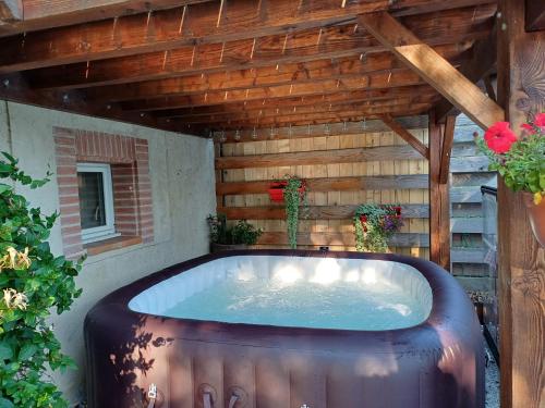 a large hot tub in a backyard with a roof at Le COULOUMIER côté lac in Caignac