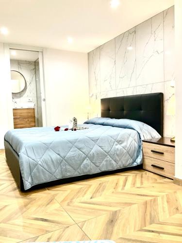 a bedroom with a large bed and a wooden floor at Gold suite19 in Catania