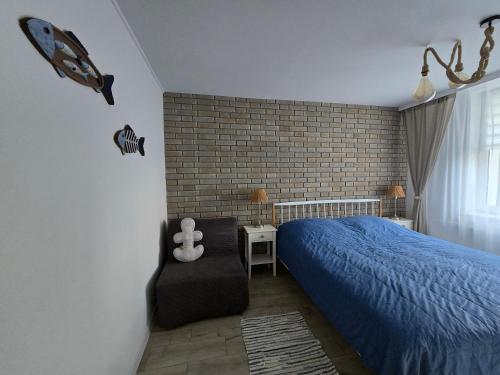 a bedroom with a blue bed and a chair at TROPIC-APARTAMENTY in Hel