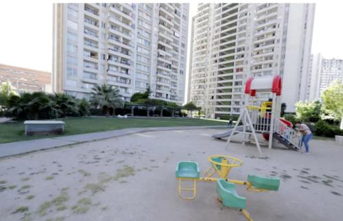 a playground with chairs on the beach with tall buildings at Departamento Vista Hermosa in Santiago