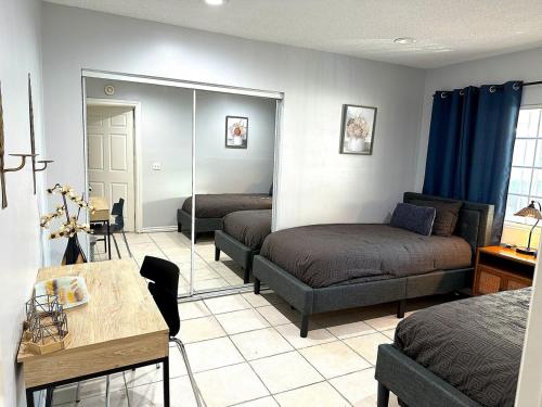 a room with two beds and a table and a table sidx sidx sidx at Tranquil Poolside Oasis with BBQ and Serene Ambiance in North Hollywood