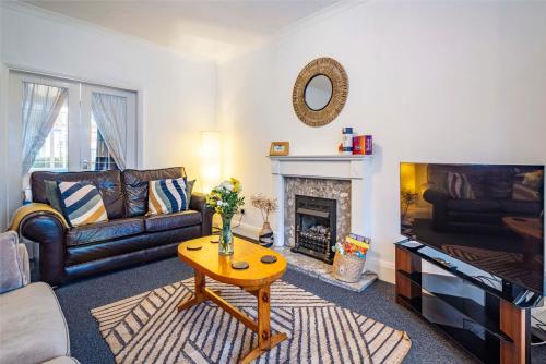 a living room with a couch and a fireplace at University View-Off-Street Parking-Sleeps 8-Fast WiFi in Nottingham