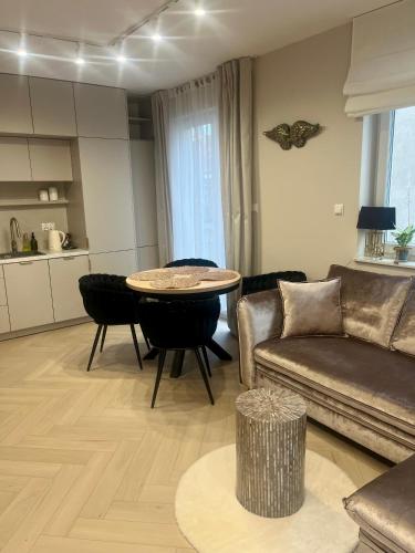 a living room with a couch and a table at Apartament Kaszmirowy in Bielsko-Biała