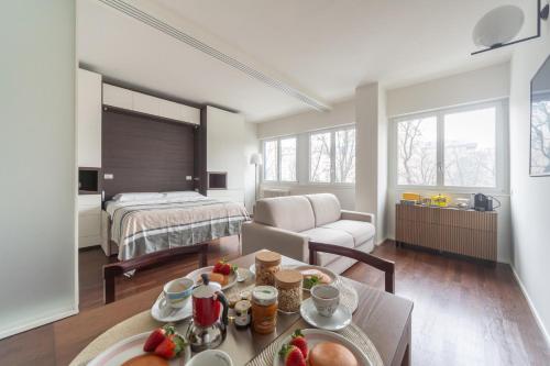 a room with a bed and a table with food on it at Charming & Bright Apartment near Milan's Fashion District in Milan