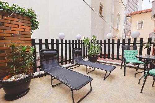 a patio with chairs and tables and a fence at AMMOTTI Hotel in Ohrid