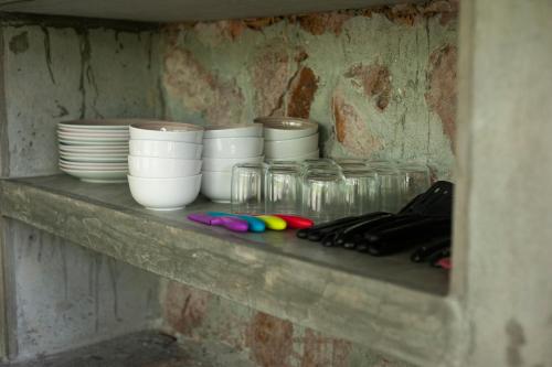 a shelf with bowls and plates on it at La Chamba Surf House in Santa Catalina