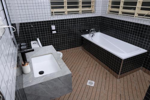 a bathroom with a toilet and a bath tub at Kabalega Resort - Hoima in Hoima