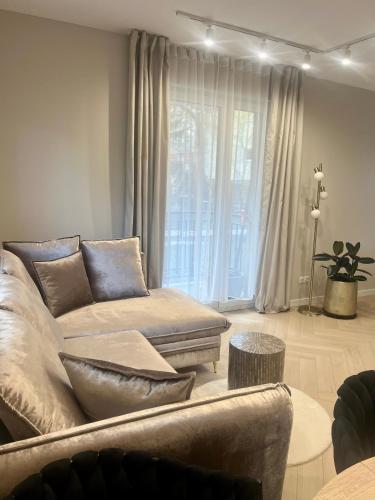 a living room with a couch and a large window at Apartament Kaszmirowy in Bielsko-Biała