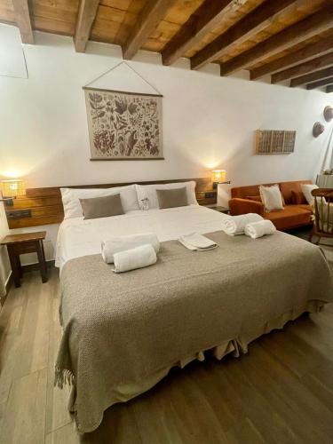 a bedroom with a large bed with two towels on it at La Casa del Cantero in Pinilla del Valle