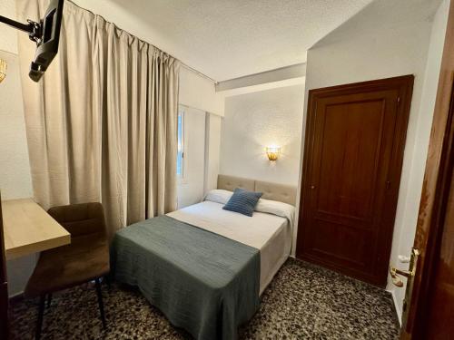 a small bedroom with a bed and a door at Hotel BH Los Ángeles in Benidorm