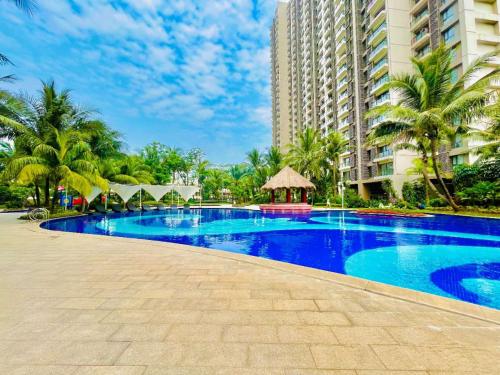 a large blue swimming pool in front of a building at Sky House BSD 3 Bedroom 70m2 View Pool Dan Garden in Samporo
