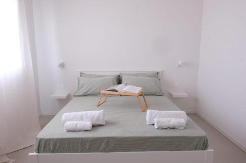 a white room with a bed with a table on it at Temples and Sea view Apartment in Agrigento