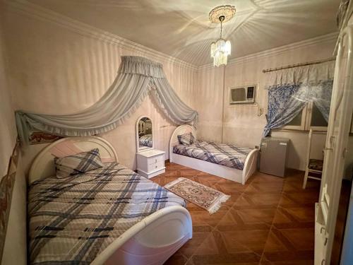 a bedroom with two beds and a chandelier at Luxury Lodge for Men in Cairo