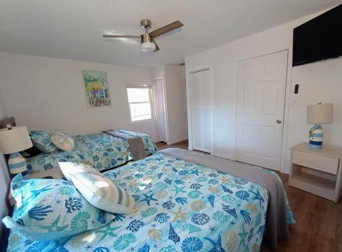 a bedroom with two beds with blue and white sheets at St Pete heated pool hot tub 5 min to the beach in St Petersburg