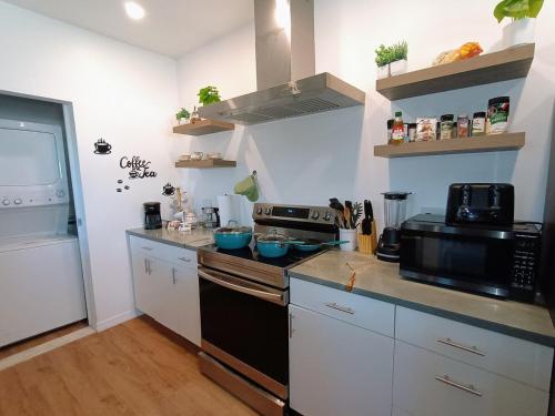 a kitchen with a stove and a microwave at St Pete heated pool hot tub 5 min to the beach in St Petersburg