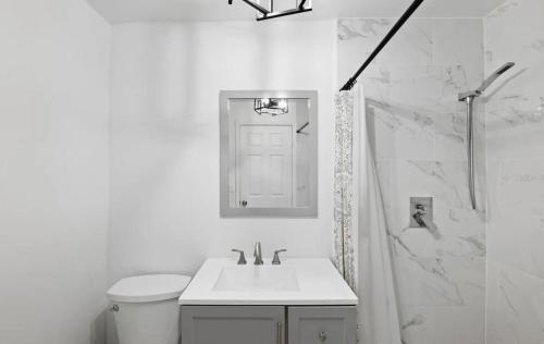 a white bathroom with a sink and a shower at St Pete heated pool hot tub 5 min to the beach in St Petersburg