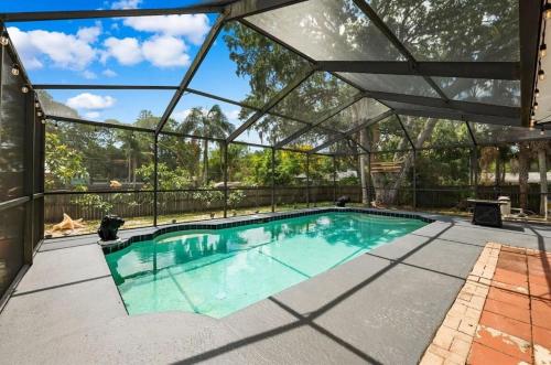 an indoor swimming pool with a glass roof at St Pete heated pool hot tub 5 min to the beach in St Petersburg