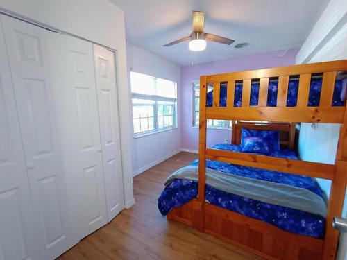 a bedroom with a bunk bed and a ceiling fan at St Pete heated pool hot tub 5 min to the beach in St Petersburg