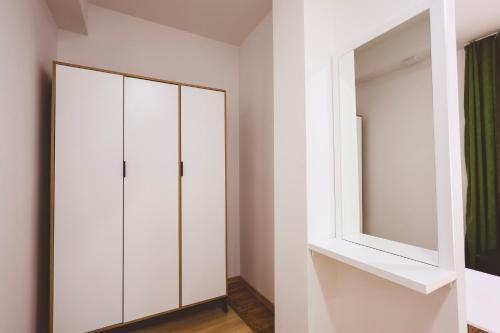 a bedroom with white cabinets and a mirror at AMMOTTI Hotel in Ohrid