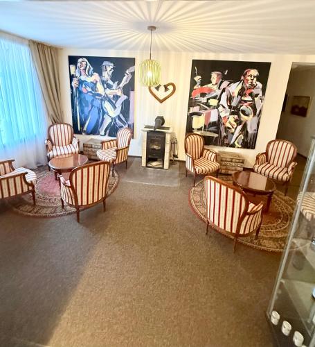 a living room with chairs and tables and a painting at Old Town Hotel Bohema, Klaipėda in Klaipėda