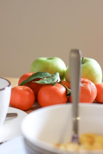 a bowl of fruit with apples and oranges on a table at Boutique Hostel Livia in Metković