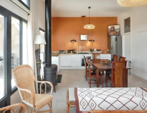 une cuisine et une salle à manger avec une table et des chaises dans l'établissement Maison spacieuse à Soulac-sur-Mer avec jardin, à Soulac-sur-Mer