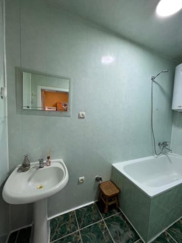 a white bathroom with a sink and a bath tub at Міні-готель Міраж in Yasinya
