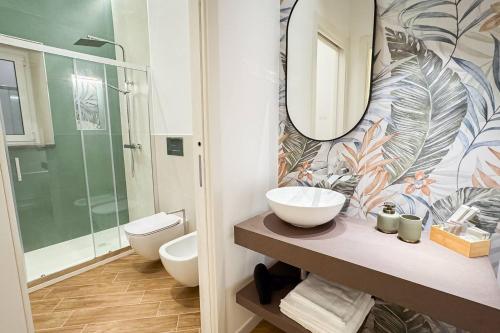 a bathroom with a sink and a toilet and a mirror at Giandra Rooms and Garden in Messina