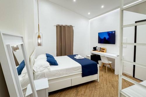 a white bedroom with a bed and a desk at Giandra Rooms and Garden in Messina