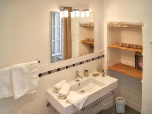 a white bathroom with a sink and a mirror at Villa spacieuse à Oppède avec piscine et vue imprenable in Oppède